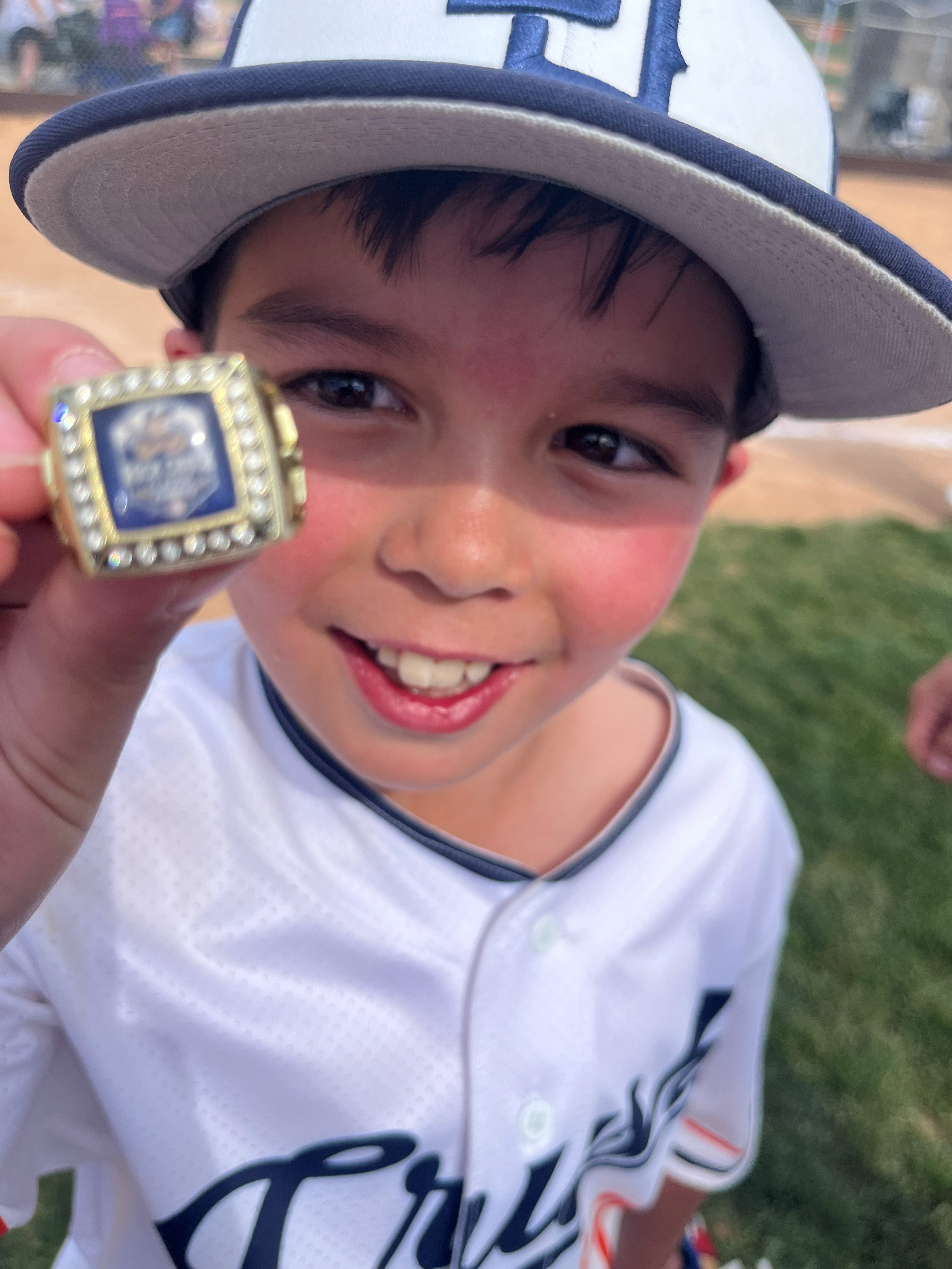 10u player holding a championship ring